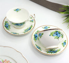 Load image into Gallery viewer, Tea cup and saucer set with floral design on a white surface
