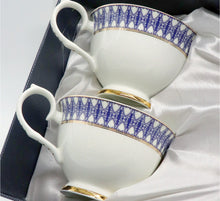 Load image into Gallery viewer, White teacup and saucer with blue and gold patterns on a white background

