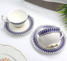 Load image into Gallery viewer, Two ceramic tea cups with blue and gold decorative patterns on a white surface.
